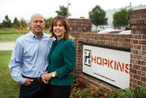 Owners in front of sign